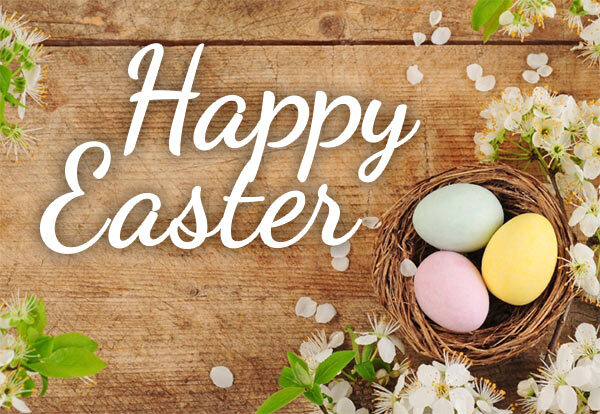 Happy Easter. A nest with three eggs in it surrounded by flowers.